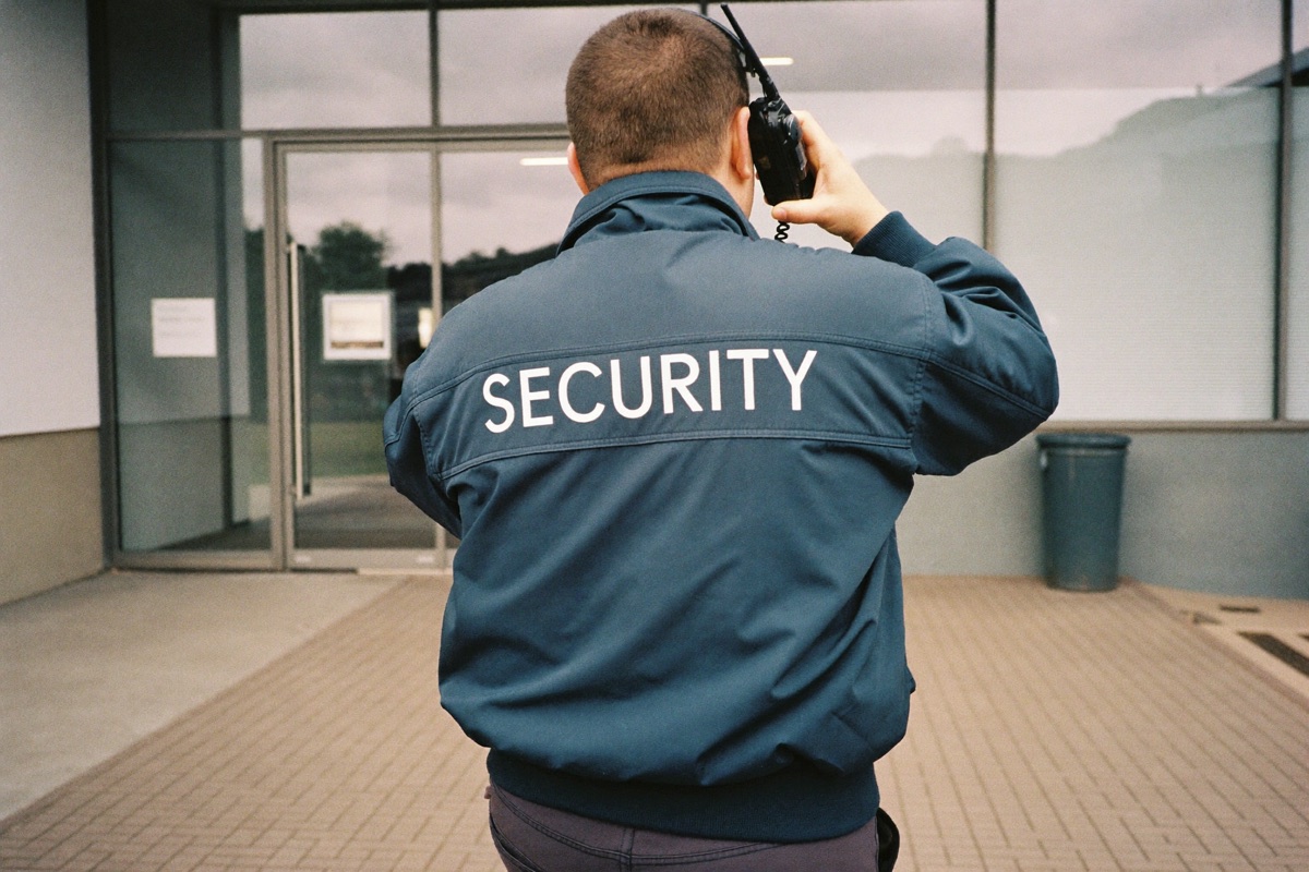 Security guard with a two-way radio in front of an office building entrance